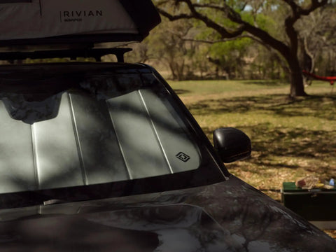 Custom Fit Rivian R2 Front Sunshade Keeps Your Whip Cool And Blocks Harsh UV Rays With Easy Fold Design And Sleek Matte Silver Finish on windshield.
