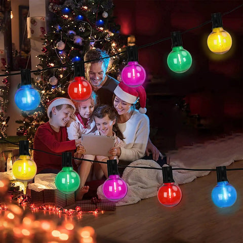 Family enjoying Christmas with Multicolor Outdoor String Lights 25 Feet With 27 LED Bulbs Waterproof Patio Decor glowing in background