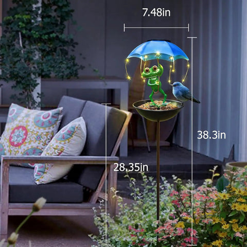 Totally Solar Frog Bird Feeder With Umbrella Garden Solar Powered Lights for Yard Decor lit in outdoor garden next to a sofa