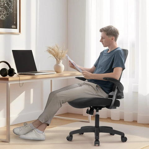 Person sitting on an Ergonomic Mesh Office And Gaming Chair With High Back Rolling Casters All Day Comfort Adjustable Lumbar Support Waterfall Seat Flip Up Armrests Height Adjustable Ideal For Home Office And Gaming Black at desk.