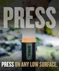 Hand using UltraPress Replacement Purifier Cartridge for Portable Water Purifier Bottle Orange in outdoor setting.