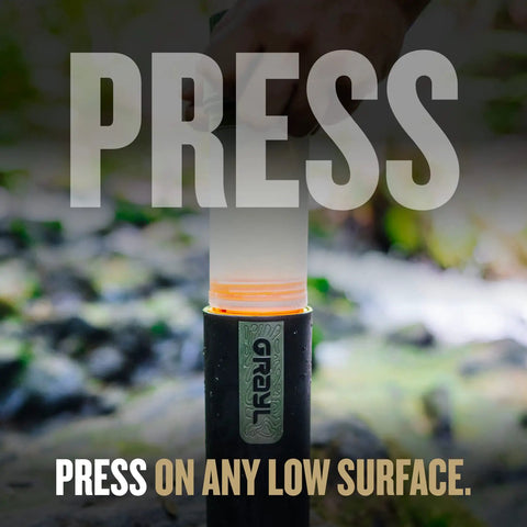 Hand using UltraPress Replacement Purifier Cartridge for Portable Water Purifier Bottle Orange in outdoor setting.