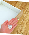 Eight Piece Stainless Steel Self Adhesive Caster Wheels With Smooth Ball Bearings For Effortless Furniture Relocation And Heavy Duty Storage Box Glide Conversion Today in hand above empty drawer.
