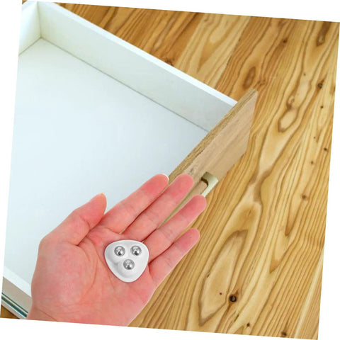 Eight Piece Stainless Steel Self Adhesive Caster Wheels With Smooth Ball Bearings For Effortless Furniture Relocation And Heavy Duty Storage Box Glide Conversion Today in hand above empty drawer.