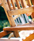 Applying Premium Clear Wood Stain With Semi Gloss Finish on a wooden chair slat outdoor, preserving its natural grain.