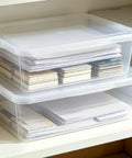 Heavy Duty Clear Plastic Storage Bins Are The Real Deal With Secure Snap Top Lid Stackable Under Bed Totes 28 Quart holding papers on a shelf.