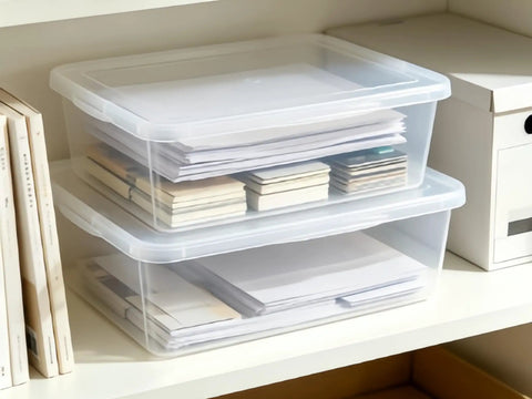 Heavy Duty Clear Plastic Storage Bins Are The Real Deal With Secure Snap Top Lid Stackable Under Bed Totes 28 Quart holding papers on a shelf.