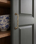 Solid Brass Cabinet Pulls With 5 Inch Hole Centers on gray kitchen cabinet showcasing ergonomic wave design and antique brass finish.