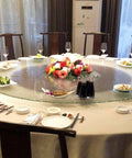 Elegant dining setup with 31 Inch To 35 Inch Tempered Glass Lazy Susan Turntable, floral centerpiece, plates, and glasses