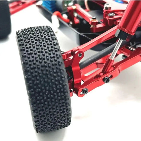 Level Up Your Bash Truck Setup With These Built Tough Aluminum Steering Blocks And Rear Wheel Hubs Crafted To Deliver Superior Grip As Direct Fit Replacement For 144016 144018 Rc Crawlers In Bright Yellow Finish. Close-up of RC truck tire and red aluminum components.