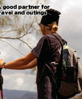 Person holding a trekking pole with a backpack featuring a lightweight travel folding tripod camping stool portable chair inside