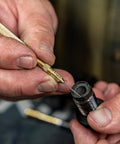 Close-up of hands using the straight pick from the Caliber 50 Muzzleloader Cleaning Kit With Caliber Specific Bronze Bore Brush.