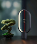 Balance Lamp For Bedroom And Nightstand With Touch Dimmer, Rechargeable LED Table Lamp, Sleek Black Finish next to bonsai tree
