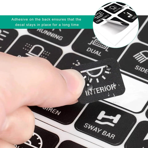 Close-up of 120 Piece Car Switch Panel Sticker Kit with Durable PVC Decals for auto console buttons being applied by hand.