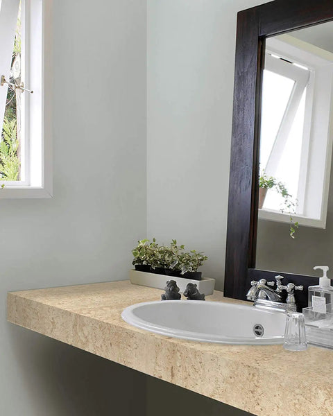 Bathroom countertop with Beige Marble Self-Adhesive Film Roll 17x78 Inches, 2 Pack, installed, near sink with mirror and window.