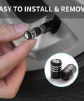 Hand installing Mercedes Benz Tire Valve Stem Cap Covers 4 Pack Aluminum Alloy Air Valve Caps Black Corrosion Resistant on wheel