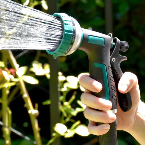 Person using 9 pattern sprayer for Retractable Garden Hose Reel With 100 Ft 5/8 Inch Hose Wall Mounted 180 Degree Swivel Bracket