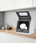 Hassle-Free Countertop Dishwasher With A Slick Stainless Steel Interior on a kitchen counter, holding clean plates.
