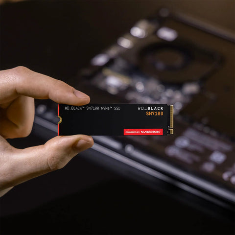 Person holding SN7100 1TB NVMe SSD Gen4 PCIe M2 2280 Up To 7250 MBps Read Speed And 6900 MBps Write Speed for laptops