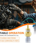 Engine coolant temperature sensor with brass threaded body and blue connector; mechanic working on engine