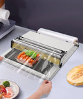 Rock Solid No Sweat Hand Cling Wrap Sealer And 18 Inch Food Packaging Machine with fresh vegetables being wrapped on a kitchen counter.