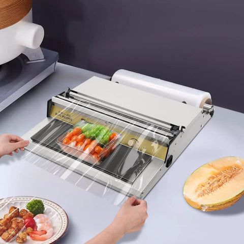 Rock Solid No Sweat Hand Cling Wrap Sealer And 18 Inch Food Packaging Machine with fresh vegetables being wrapped on a kitchen counter.
