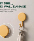 15 Pack Self Adhesive Wall Hooks With Hella Strong Grip No Drilling Damage Free Mounting For Towels Keys And Flatware Decorative Cutesy Style featuring yellow adhesive hook mounted on wall.