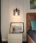 Set Of Two 8 Inch Battery Wall Sconces With Clear Glass, Farmhouse Indoor Lighting, 4000k Neutral White, Rechargeable Remote Dimmable Fixtures mounted beside a bed.