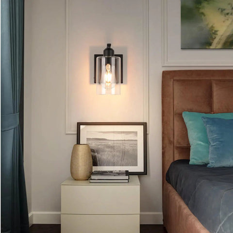 Set Of Two 8 Inch Battery Wall Sconces With Clear Glass, Farmhouse Indoor Lighting, 4000k Neutral White, Rechargeable Remote Dimmable Fixtures mounted beside a bed.