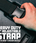 Close-up of a hand gripping a heavy duty 2 inch adjustable strap with high tension buckle on a drum case.