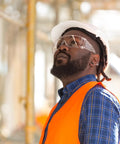 Worker wearing 12 Pack Safety Glasses Over Eyeglasses With Anti Fog And Scratch Resistant ANSI Z87 Protective Eyewear on construction site.