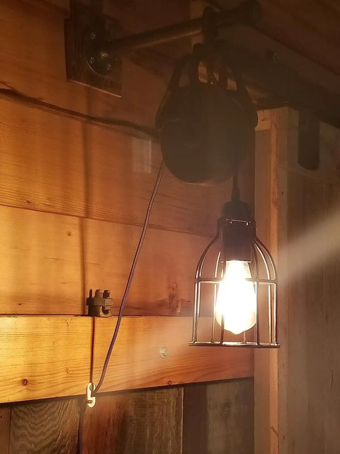 Premium Black Metal Wire Cage Lamp Guard For Ceiling Fans And Pendant Lights Killer Diamond Shape Light Cover With Slick Rust Resistant Coating Set Of Two, installed on wall with light bulb.
