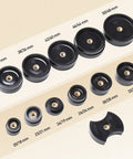 Assorted sizes of round black press tools from the All In One Watch Repair Tool Kit With Press Tool And Link Removal Set