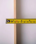 Close-up of a 21-inch American-Made Basswood Paint Stir Stick with a measuring tape showing its width for 5-gallon buckets.