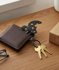 Slim Metal Multitool Card With Screwdriver And Bottle Opener Credit Card Size in a wallet with keys on table