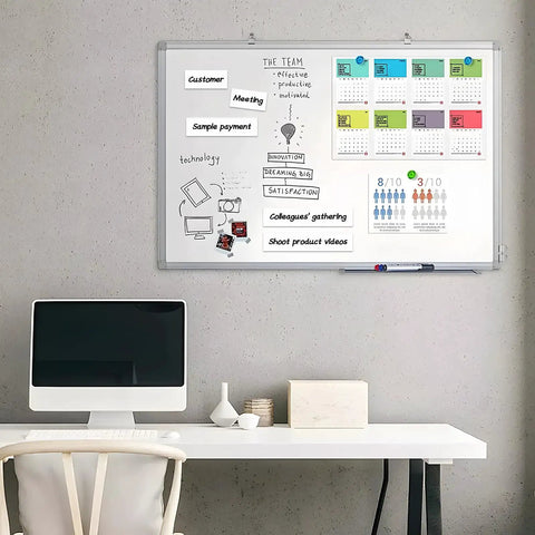 Whiteboard with dry erase magnetic tape roll used for organization, showing labeled strips and calendar, desk setup in front