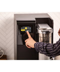 Person using touchscreen on K-3500 Single Serve Commercial Coffee Maker For Busy Offices, 150 Plus Pod Varieties.