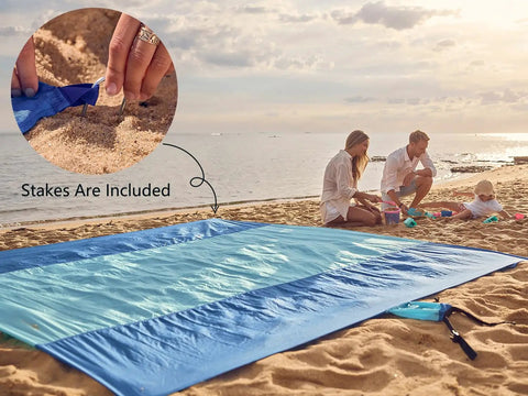 Family on beach beside Sandproof Beach Blanket With 6 Stakes And 4 Corner Pockets Large 7 By 7 Feet 210 Cm Square Quick Dry