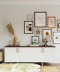 White sideboard with art gallery wall above, featuring Ten Pack 5 Inch Cabinet Handles With Champagne Bronze Finish For Kitchen Cupboards.