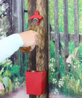 Red Cast Iron Wall Mounted Bottle Cap Opener Set With Open Here Embossed, bottle being opened with cap catcher.