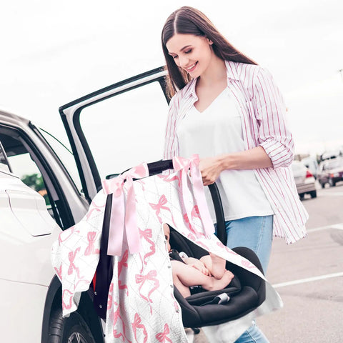 Woman using Pink Bow 2-In-1 Muslin Baby Car Seat Cover Breathable Nursing Shield For Breastfeeding on a car seat.