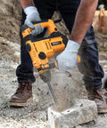 Man using Beast Of A 900W Rotary Hammer Drill With 26mm Concrete Capacity, 2-Function Hammer And Drill Modes on concrete block