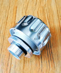 Close-up of a 2 Pack Quarter Inch NPT Breather Cap with Forty Micron Filtration for hydraulic systems, showcasing metal finish on wood surface.