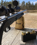 Rifle on table with Brass and Beefy 1000 Denier Shooting Rest Bag Pre Filled Rifle Support for Long Range Outdoor Range and Hunting Use Portable Lightweight Gun Holder Sack for Stability and Precision