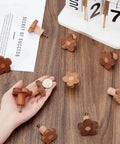 10 Pcs Flower Wooden Cabinet Knobs In Coconut Brown, Two Sizes displayed with a calendar and hand holding one knob for scale