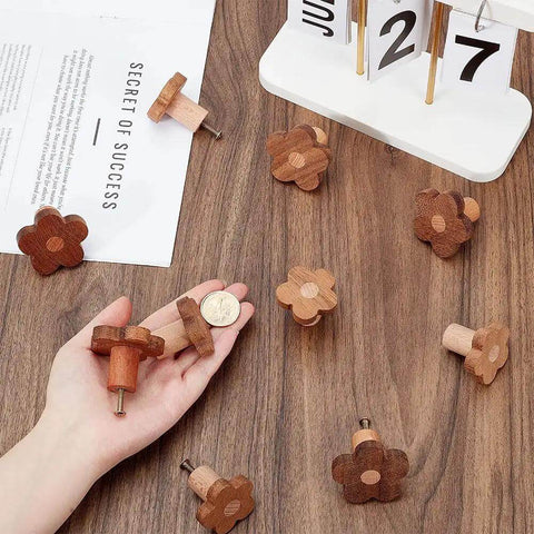 10 Pcs Flower Wooden Cabinet Knobs In Coconut Brown, Two Sizes displayed with a calendar and hand holding one knob for scale