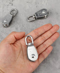 Heavy Duty 16 Pack M15 Single Pulley Block With 304 Stainless Steel Rope Roller shown in hand and on surface