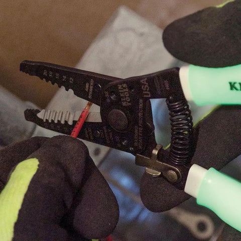 Glow In The Dark Grips Wire Stripper And Cutter With Serrated Curve Nose For 10 To 18 AWG Solid And 12 To 20 AWG Stranded Wire Pro Grade Tool Made In USA, showing wire stripping in progress