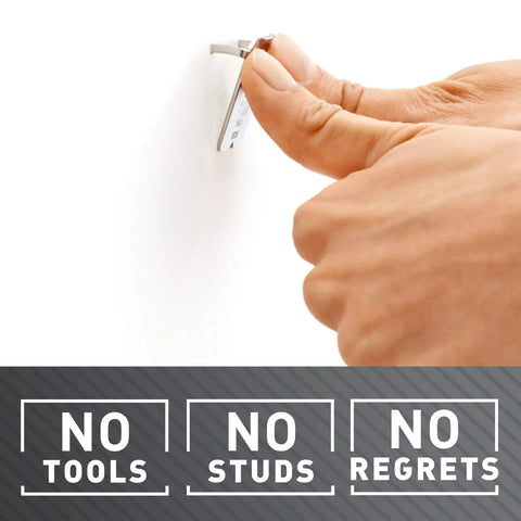 Hand installing Heavy Duty Drywall Picture Hangers Six Pack Holds Up To 15 Lbs Each With No Studs Required for easy wall mounting.