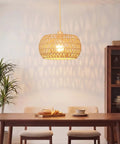 Qingmiao Boho Plug in Pendant Light with handwoven shade illuminating a dining table, 14ft cord, showcasing warm light.